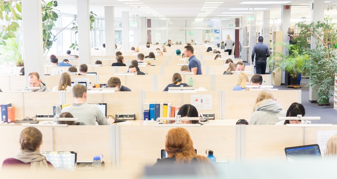 Studierende arbeiten an Laptops in der Bibliothek der rechtswissenschaftlichen Fakultät.